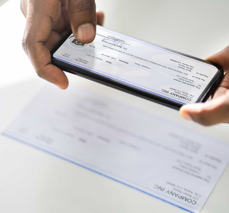 hands snapping photo of check with mobile phone